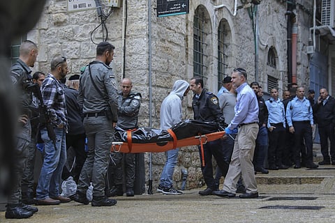 Israeli security personnel and members of Zaka Rescue and Recovery team carry the body of a Palestinian man who was fatally shot by Israeli police after he killed one Israeli and wounded four. (AP)