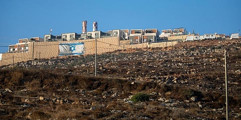 An Israeli flag is painted on the surrounding wall of the West Bank Jewish settlement of Migdalim near the Palestinian town of Nablus. (Photo | AP)