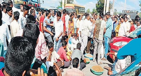 Farmers belonging to Devunipalli village in Kamareddy district stage a dharna at Kamareddy-Sircilla road demanding purchase of their crops, on Monday. (Photo| EPS)