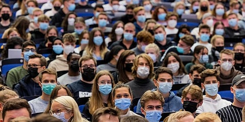 Students wear mouth-to-nose coverings while sitting close to each other during the lecture 'BWL 1' in lecture hall H1 of the Westfaelische Wilhelms-Universitaet in Muenster, Germany. (Photo | AP)