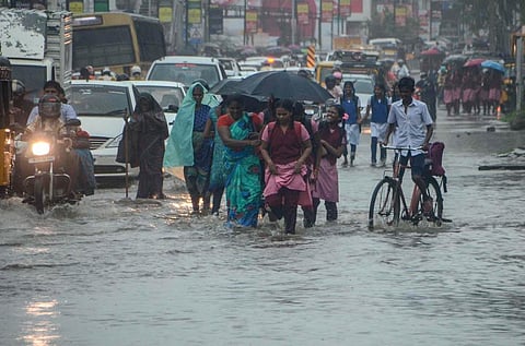 Students wade through stagnated rain water in Tirunelveli on November 26, 2021. (Photo | V Karthikalagu, EPS)