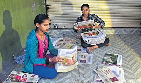 Pramila and Pavithra arrange newspapers before going to deliver the dailies at Motinagar in Hyderabad. (Photo| EPS/S Senbagapandiyan)