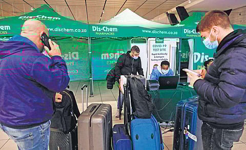 Travellers queue at a check-in counter at Johannesburg airport. Many countries have banned flights from South Africa. (Photo | AFP)
