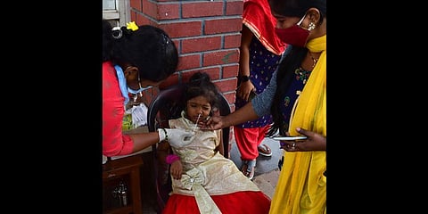Healthcare workers collect swab samples of a child at the Kempegowda Bus Station in Bengaluru on Saturday | Shriram BN