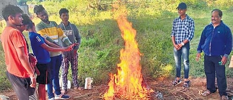 People gather around a bonfire in Daringbadi. (Photo | Express)