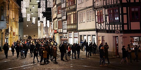 People with candles walk along the old town of Erfurt, Germany. (Photo | AP)
