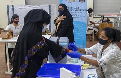 A woman hold her arm after receiving Covishield COVID-19 vaccine at a vaccination center in Mumbai, India, Monday, Nov. 29, 2021. (Photo | AP)