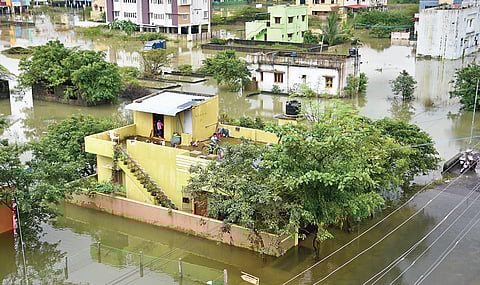 A boy rides cycle on the terrace of his house after his locality has been affected by flooding at Varadharajapuram in Tambaram on Monday | Ashwin Prasath
