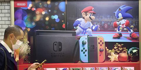 A man walks by in front of poster of Nintendo in Tokyo on Dec. 17, 2019. (Photo | AP)