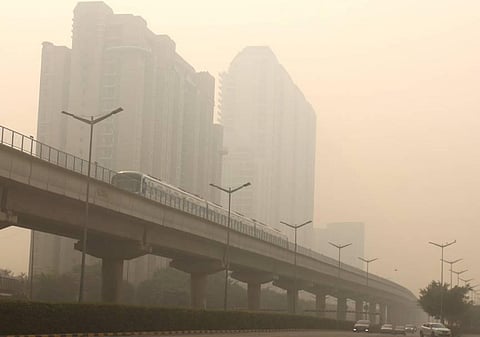 A metro train runs on a railway track amid low visibility due to a thick layer of smog, following Diwali celebrations in Gurugram.