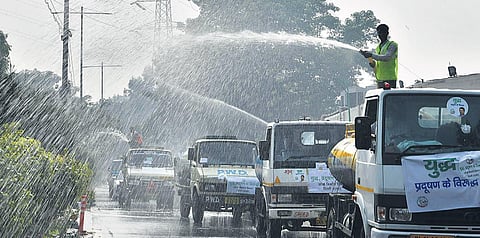 Water being sprayed on the road even as a thick layer of smog engulfed Delhi for the seconed day after Diwali. (Photo | EPS/Shekhar Yadav)