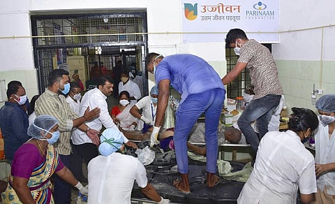 A man is carried for treatment after a fire in a hospital's COVID-19 ward that caught fire in Ahmednagar. (Photo | AP)