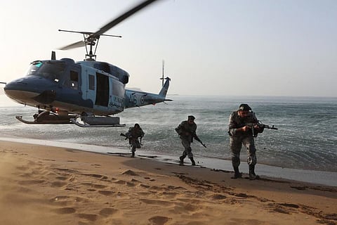 In this picture released by the Iranian Army on Saturday, Nov. 7, 2021, troops attend a maneuver in a coastal area in southeastern Iran. (Iranian Army via AP)