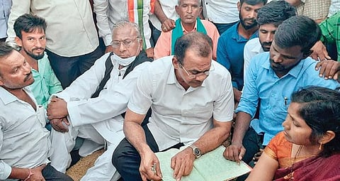 Congress MP Komatireddy Venkat Reddy inspects paddy purchase registers at the PACS procurement centre in Lingampet, on Saturday. Party senior leader V Hanumantha Rao is also seen
