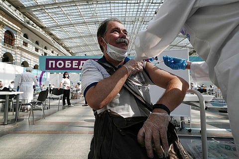A medical worker administers a shot of Russia's Sputnik V coronavirus vaccine at a vaccination center in Gostinny Dvor, a huge exhibition place in Moscow. (Photo | AP)