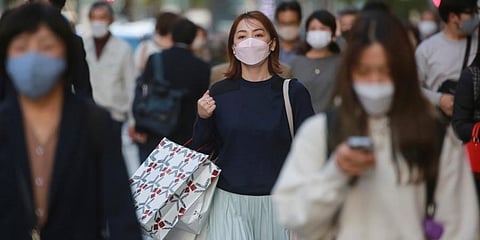 People wearing face masks to help curb the spread of the coronavirus walk at the Ginza shopping district on Tokyo. (Photo | AP)