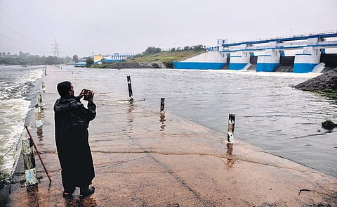 A man taking photo of water gushing out of the reservoir | DEBADATTA MALLICK