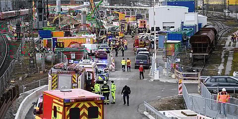 Firefighters, police officers and railway employees stand on a railway site in Munich, Germany. (Photo | AP)