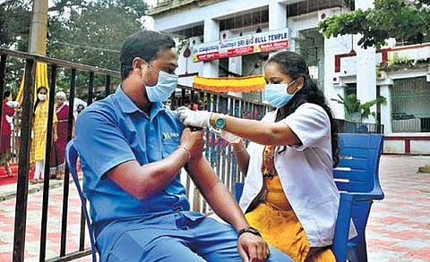 A health worker vaccinates a man at the famous Bull Temple in Bengaluru on Tuesday | Ashishkrishna H P