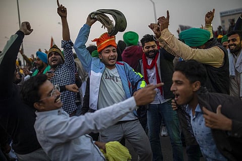 A group of Indian farmers dance at the protest site as they started to dismantle temporary structures used during protests in Ghazipur, outskirts of New Delhi. (Photo | AP)
