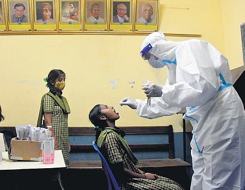 Swab samples of school students being collected at a government high school in Bhuvaneshwari Nagar, Magadi Road, in Bengaluru on Friday, Dec 10, 2021. (Photo | Express, Ashishkrishna HP)