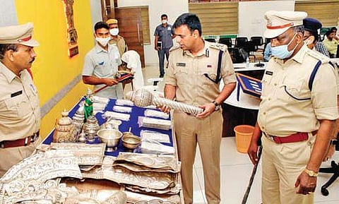Vijayawada CP Kanthi Rana Tata takes a look at the silver ornaments recovered from the inter-state temple burglar in Vijayawada on Monday, Dec 13, 2021. (Photo | Express)