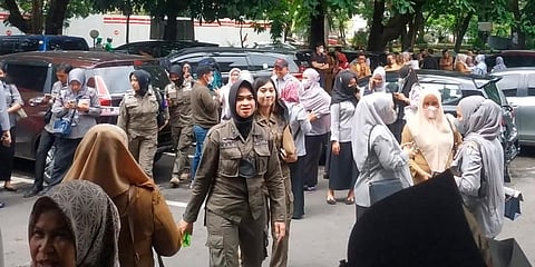 People wait outside after evacuating a government building following an earthquake in Makassar, South Sulawesi, Indonesia. (Photo | AP)