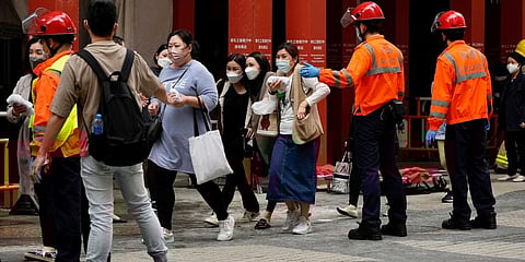 People walk out from the World Trade Centre where is located in the city's popular Causeway Bay shopping district of Hong Kong. (Photo | AP)