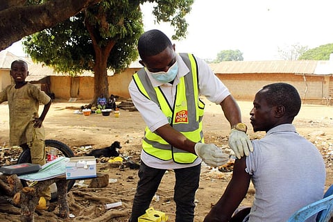 Yunusa Bawa, a community health worker, injects a man with AstraZeneca coronavirus vaccine in Sabon Kuje on the outskirts of Abuja, Nigeria. (Photo | AP)