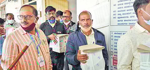 Counting staff carry ballot boxes at RDPU College in Chikkodi. (Photo | Express)
