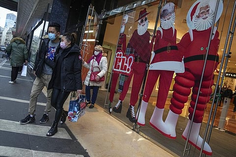 People wearing face masks to protect against COVID-19 walk out of a shopping center in Paris, Friday, Dec. 17, 2021. (Photo | AP)