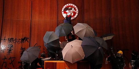 FILE - Protesters deface the Hong Kong logo at the Legislative Council to protest against the extradition bill in Hong Kong on July 1, 2019. (Photo | AP)
