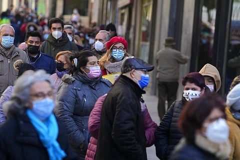 People wearing a face masks to curb the spread of COVID-19, queue to buy Christmas lottery tickets (Photo | AP)