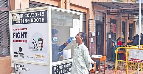 A health worker collects swab samples of a man at a primary health centre  on Kamaraj Road in Bengaluru on Wednesday | Vinod Kumar T