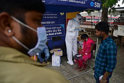 Health worker collects swab at KSRTC bus stand in Bengaluru. (Photo | Shriram BN, EPS)