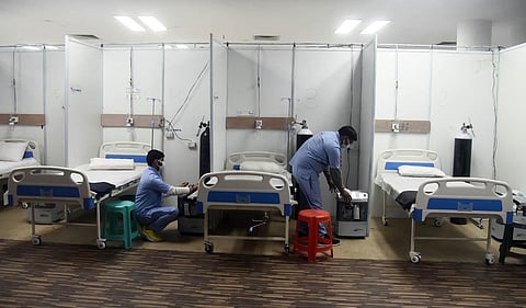 A worker prepares a bed for Covid patients in Commonwealth Games Village in view of the Omicron cases, in New Delhi. (Photo | Parveen Negi, EPS)