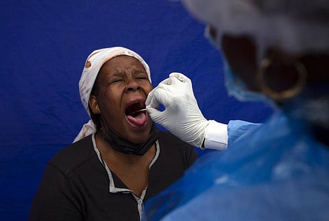 A throat swab is taken from a patient to test for COVID-19 at a facility in Soweto, South Africa, Dec. 2, 2021. (Photo | AP)
