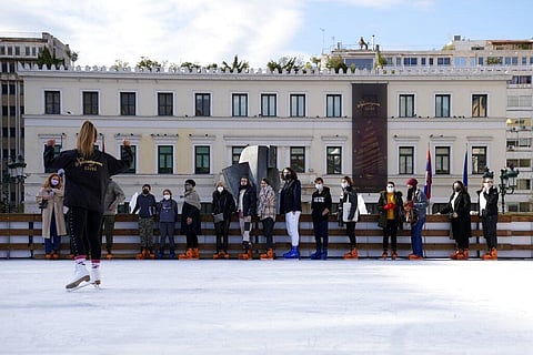 People wearing face masks to protect against the spread of coronavirus, listen to a trainer before ice skating on a rink in front of Athens City Hall, Greece. (Photo | AP)