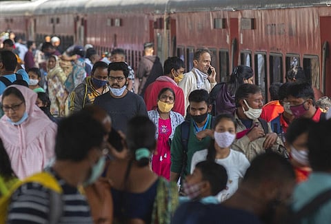 Passengers arrive wearing face masks at a train station in Mumbai, India, Thursday, Dec 23, 2021. (Photo | AP)