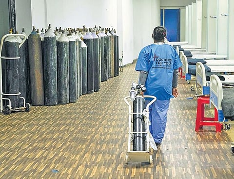 A health worker arranges an oxygen cylinder at a Covid Care Centre in Delhi (Photo| PTI)