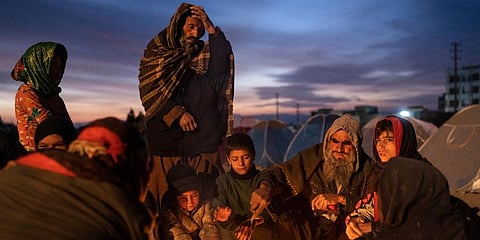 A family warm up next to makeshift fire outside the Directorate of Disaster office where they are camped, in Herat, Afghanistan. (Photo | AP)