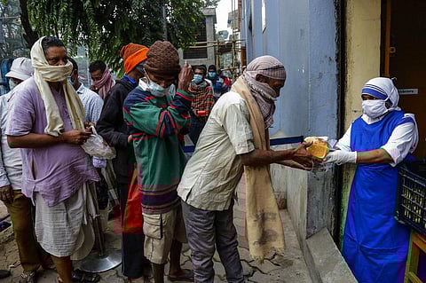 Nuns of Missionaries of Charity, the order founded by Saint Teresa, distribute food to the poor and needy its headquarter in Kolkata. (Photo | AP)