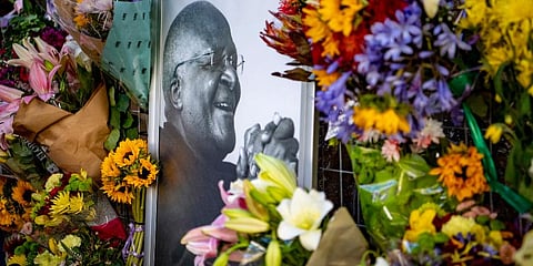 Flowers surround a portrait of former Anglican Archbishop Desmond Tutu outside St. George's Cathedral in Cape Town. (Photo | AP)