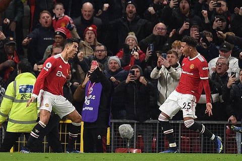 Manchester United players Cristiano Ronaldo (L) and Jadon Sancho (R) celebrate after a goal during EPL match against Arsenal at Old Trafford in Manchester, England, on Dec 2, 2021. (Photo | AFP)