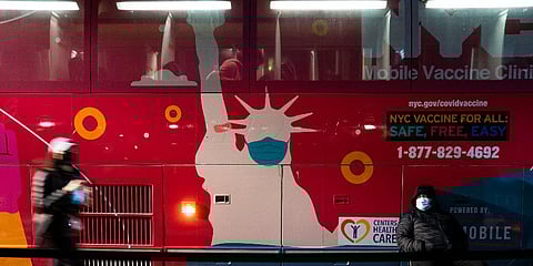 A mobile COVID-19 vaccination and booster shot site operates out of a bus on 59th Street south of Central Park as patients wait on the sidewalk, Thursday, Dec. 2, 2021, in New York. (Photo | AP)