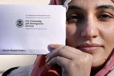 Haseena Niazi, a 24-year-old from Afghanistan, holds a parole denial notice she received from the Department of Homeland Security, while posing outside her home, Friday, Dec. 17, 2021. (AP)