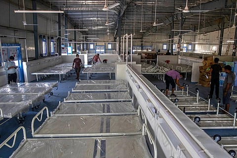 Workers arrange beds at a makeshift COVID-19 care center with 1200 beds in Mumbai, India, Friday, Dec. 31, 2021. (Photo | AP)