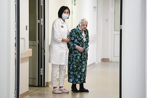 Dr. Saltanat Bekeeva, left, and 101-year-old patient Pelageya Poyarkova enter the hall to speak with media as she leaves the recovery ward for COVID-19 patients (Photo | AP)