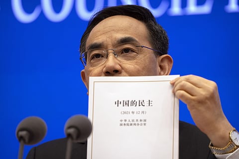 Xu Lin, vice minister of the Publicity Department of the Central Committee of China's Communist Party holds a copy of a government-produced report titled 'Democracy that Works' during a press con.