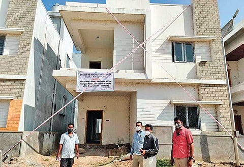 The staff and officials of  Dundigal Municipality caution buyers through banners after sealing the unauthorised villas, in Mallampet on Saturday.
